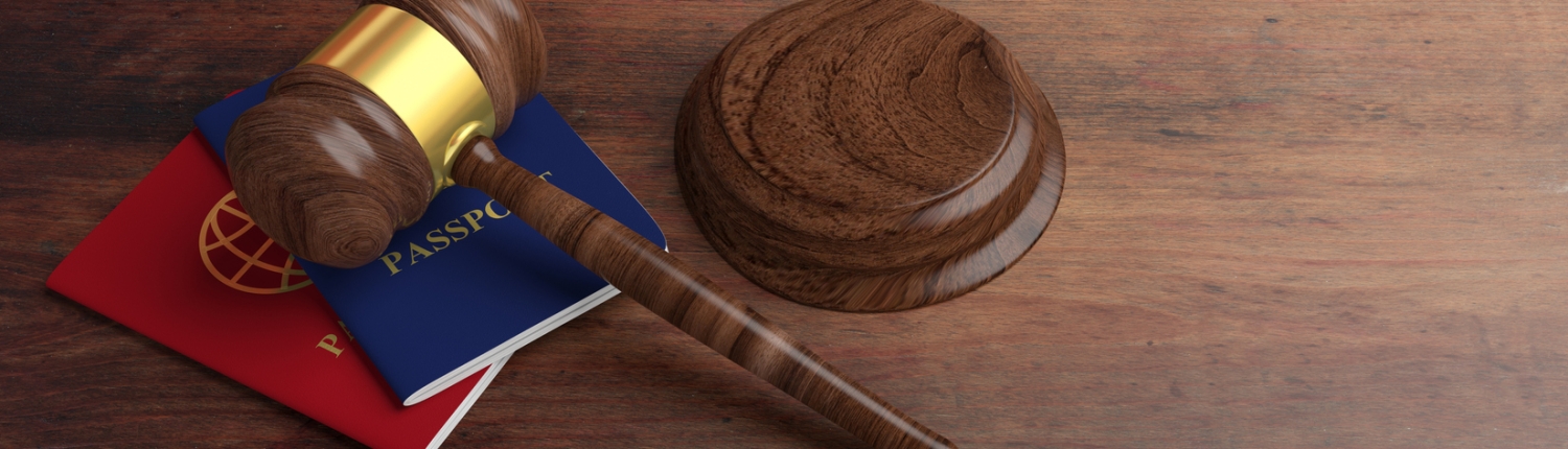 Two passports and a judge gavel on wooden desk background. 3d illustration