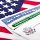 United States of America social security and green card with US flag on the background. Immigration concept. Closeup with shallow depth of field.