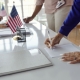 Close-up of people filling documents and voting at election day