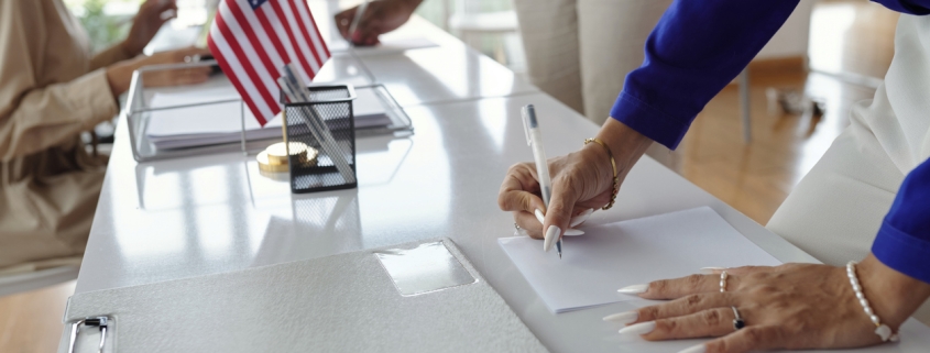 Close-up of people filling documents and voting at election day