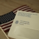 USCIS envelope on blurred Flag of USA background