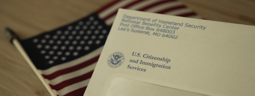 USCIS envelope on blurred Flag of USA background