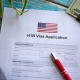 Illustrative picture showing application for United States of America work visa H1B with pen