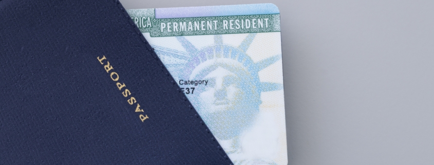 United States passport, permanent resident card (green card) on desk . Immigration concept