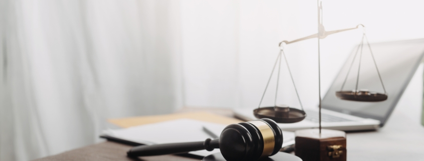 Business and lawyers discussing contract papers with brass scale on desk in office. Law, legal services, advice, justice and law concept picture with film grain effect