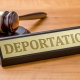 A gavel and a name plate with the engraving Deportation