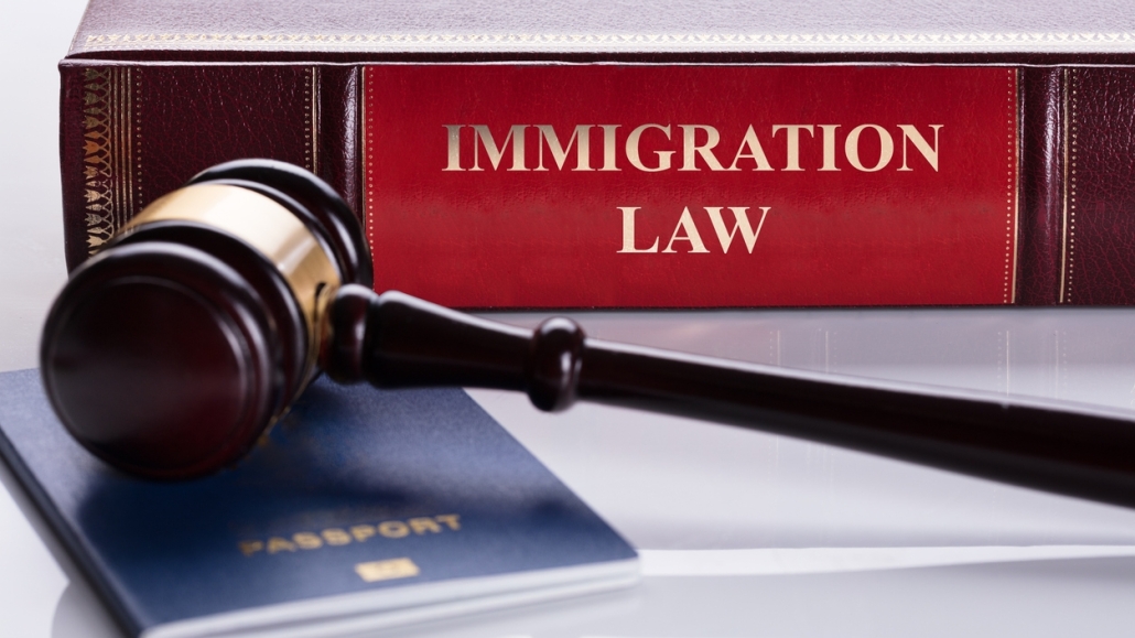 Close-up Of Gavel And Passport In Front Of Law Book