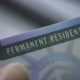 Close up view of Fragment of Permanent resident card (Green) card of USA on blurred background.